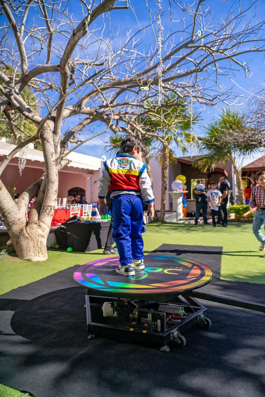 Junger Gast posiert auf einer beleuchteten 360°-Plattform bei einem Fest im Freien
